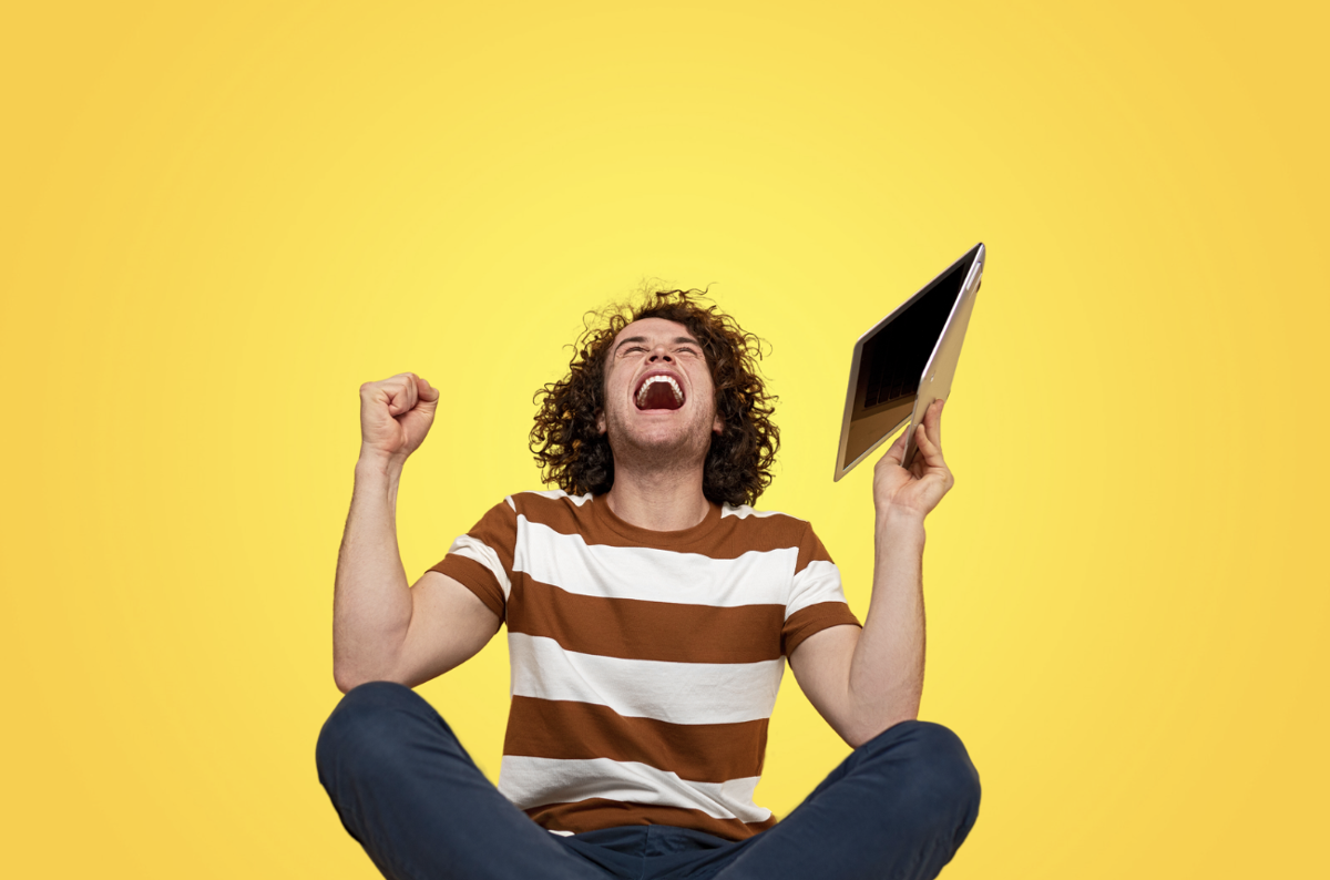 man cheering with laptop in his hand man cheering with laptop in his hand