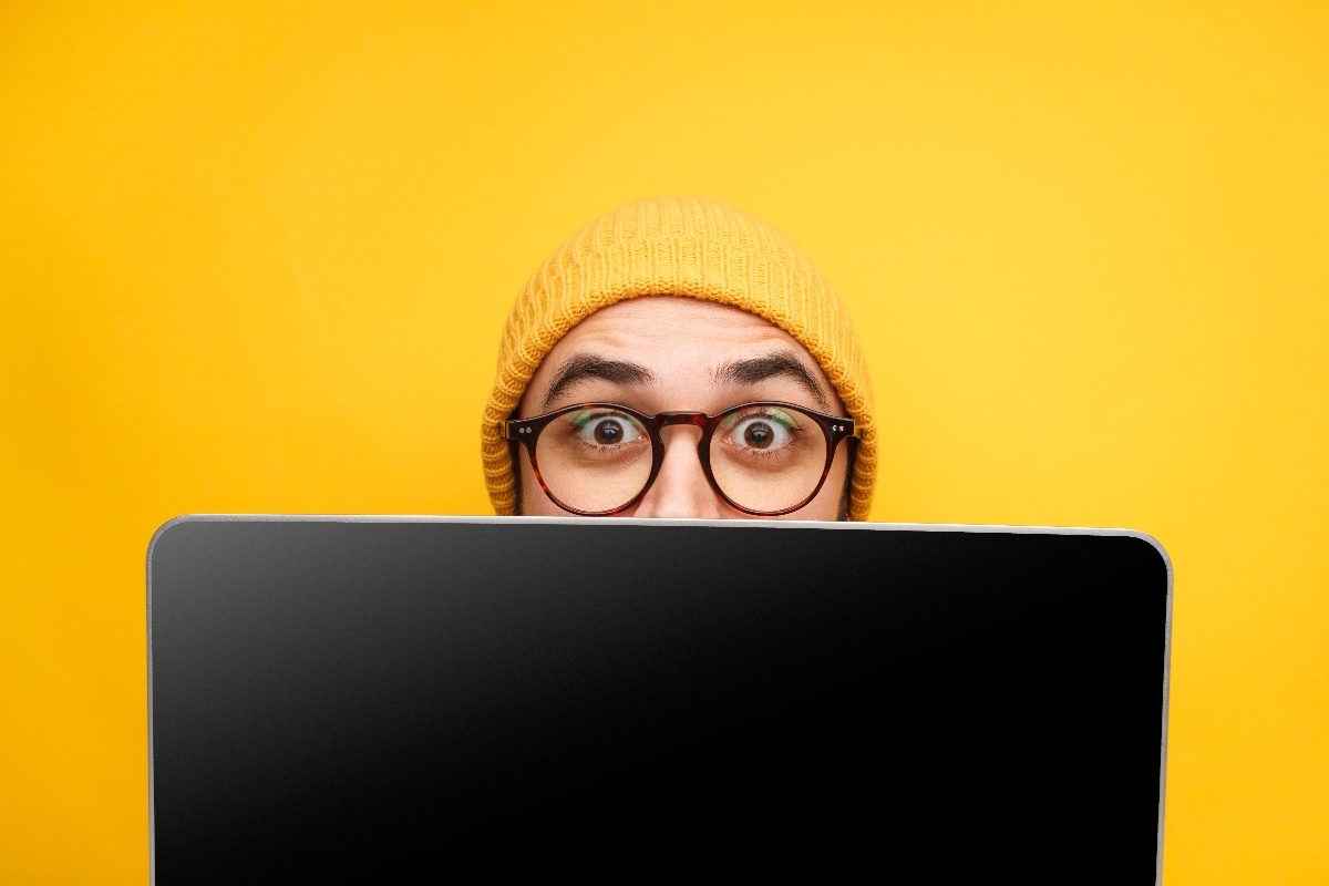 man watching behind laptop screen